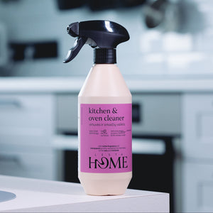 Spray bottle of kitchen and oven cleaner with pink label on a kitchen counter.
