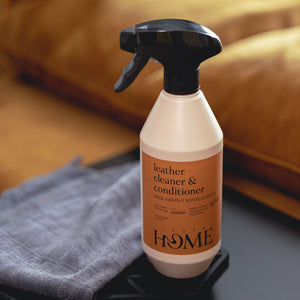 Leather cleaner and conditioner bottle with a gray cloth on a brown leather surface