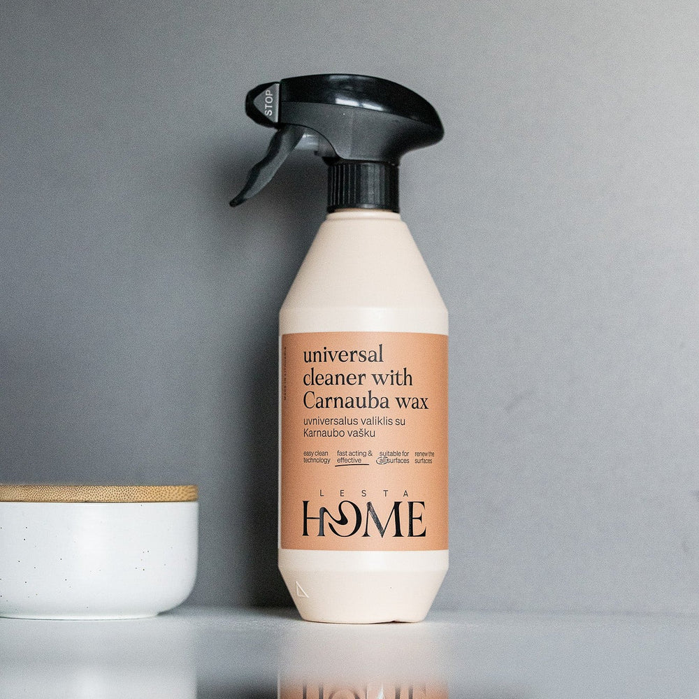 Spray bottle with beige body and black nozzle on a white background